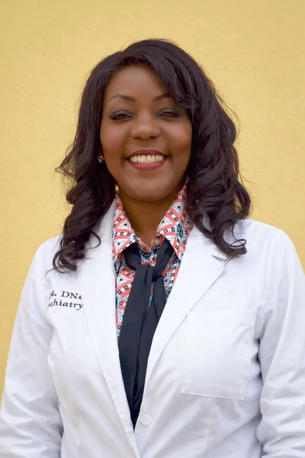 Dr. Rose Onyekwe wearing a white medical coat and smiling.