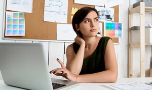Woman using a cognitive restructuring worksheet to challenge negative thoughts