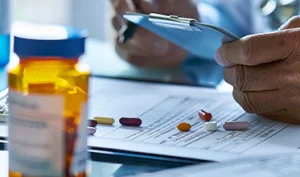 Healthcare professional reviewing medication management and prescription records