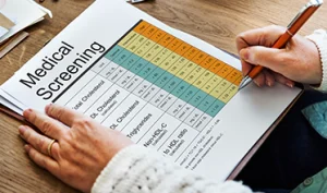 Patient completing a mood, symptom and medication tracking worksheet